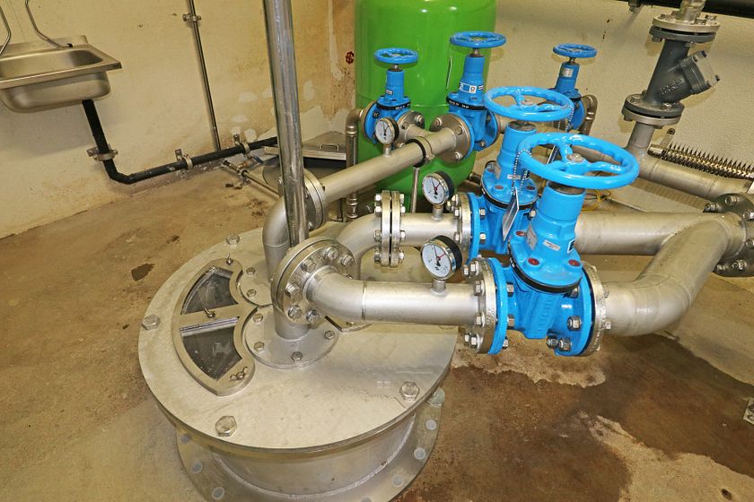 Brunnenkopf mit Edelstahlverrohrung in einem Trinkwasserpumpwerk.