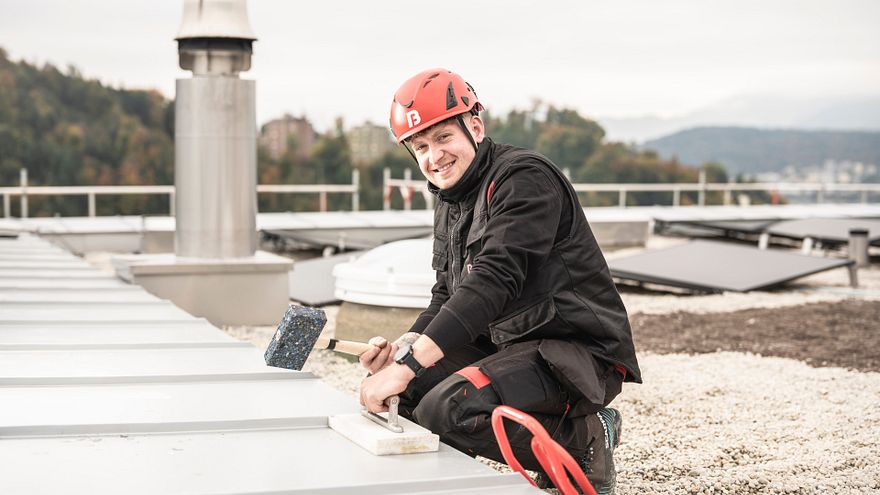 Spengler Christian auf dem Dach an Spenglerarbeiten.