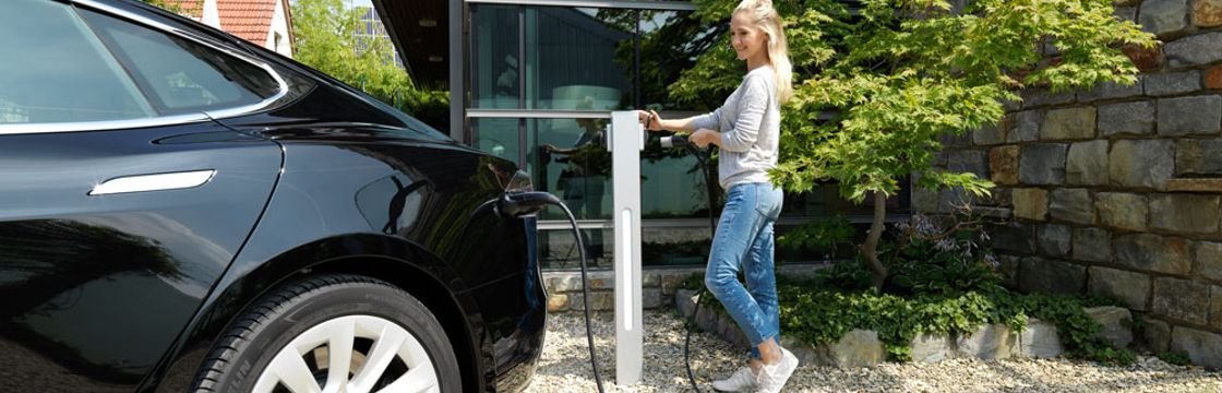 Frau, die ihr Auto auflädt